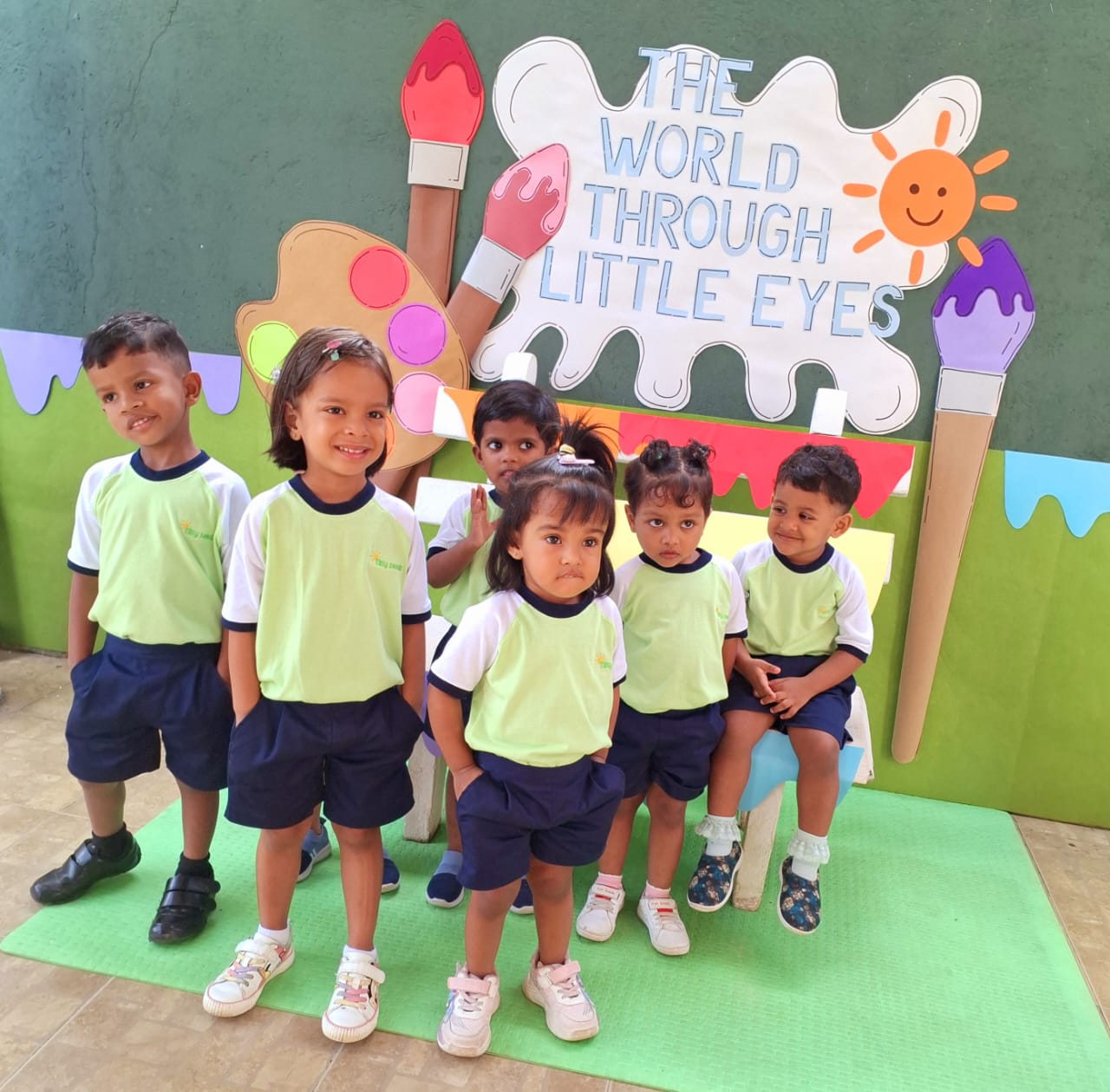 Tiny Seeds pre-schoolers in lime green and white ringer tees with navy shorts