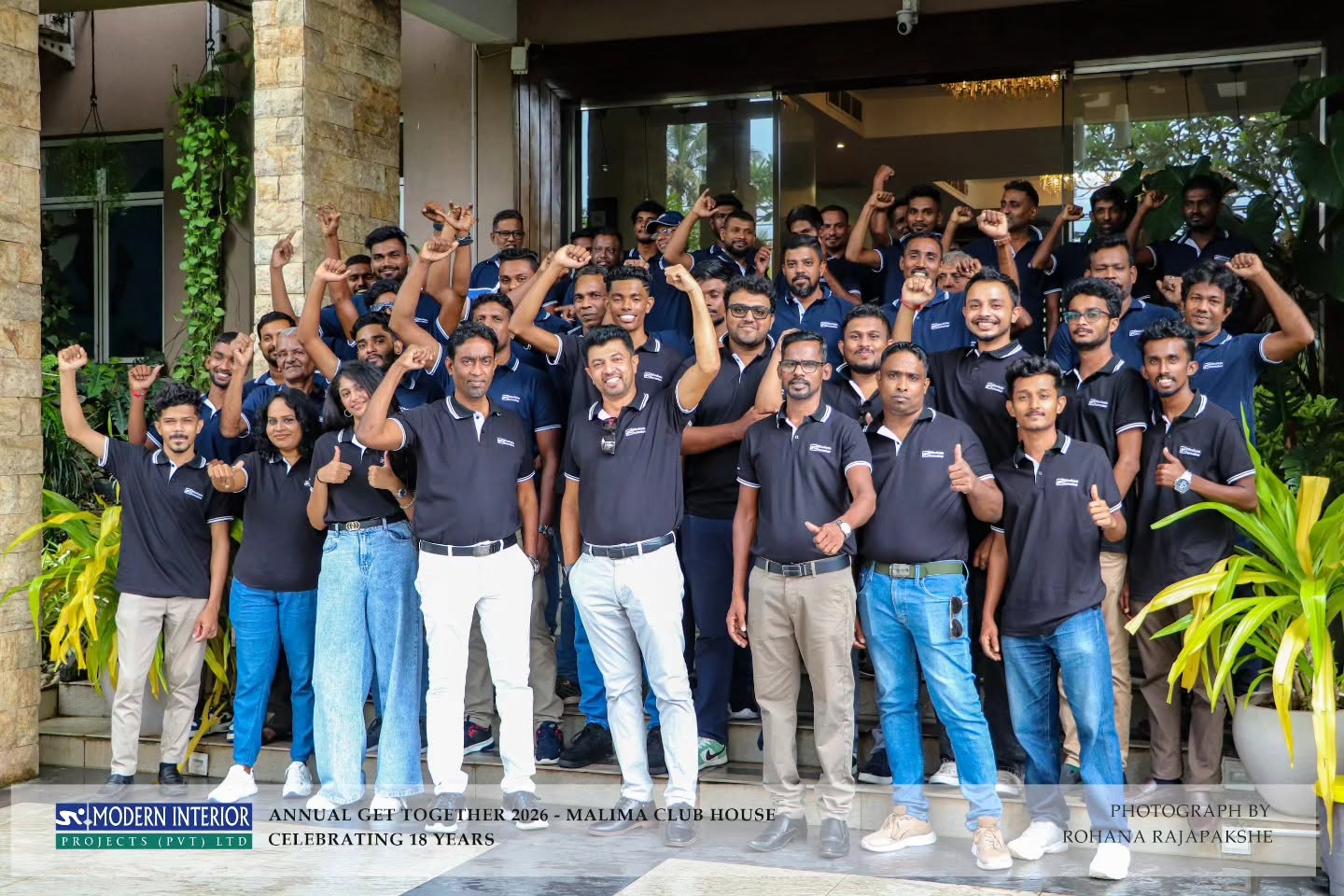 Modern Interior Projects staff team in custom black Mezzo polos with white tipping and embroidered logo at their 18-year annual get-together