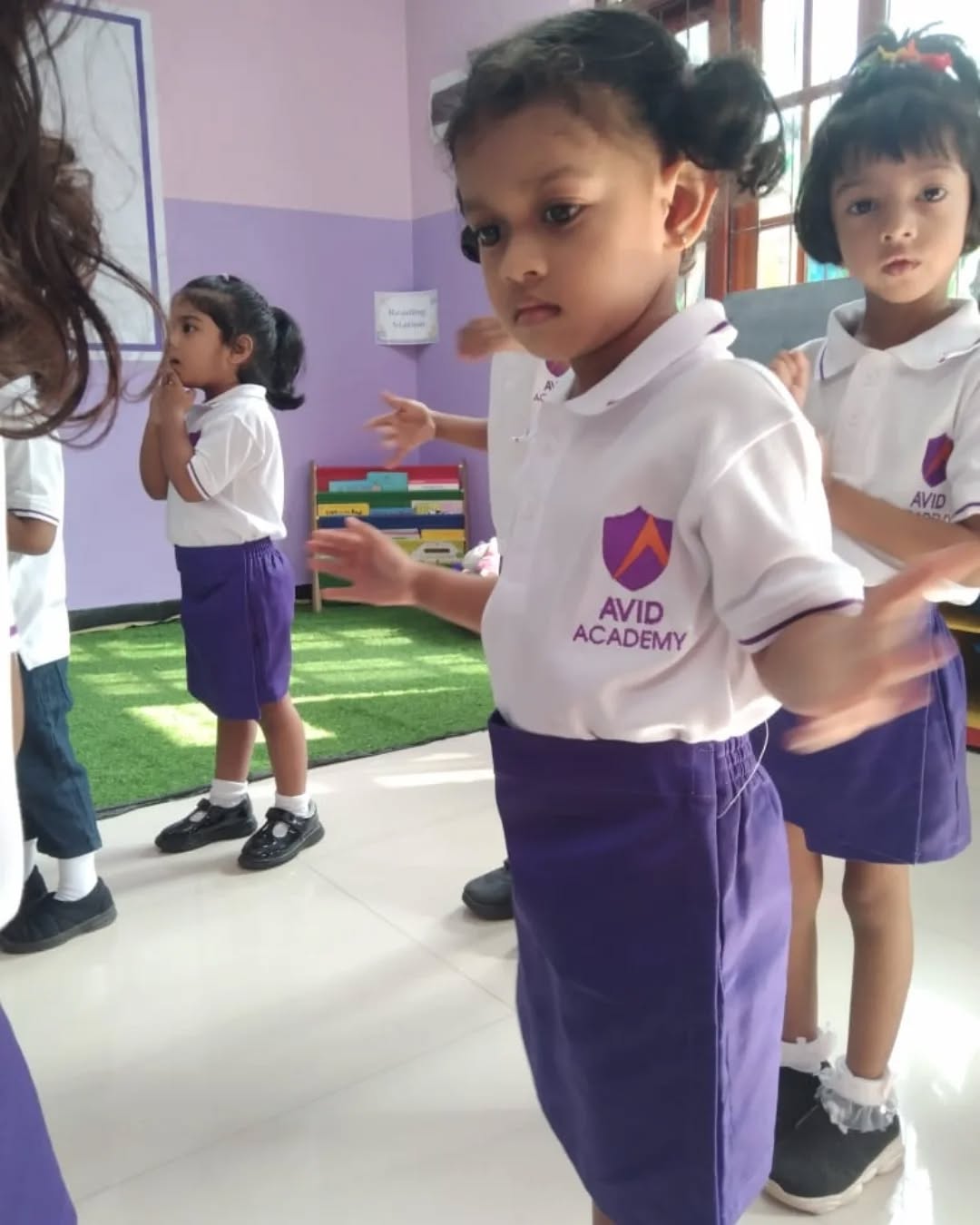 Avid Academy pre-school children in custom white polo and purple skirt uniforms