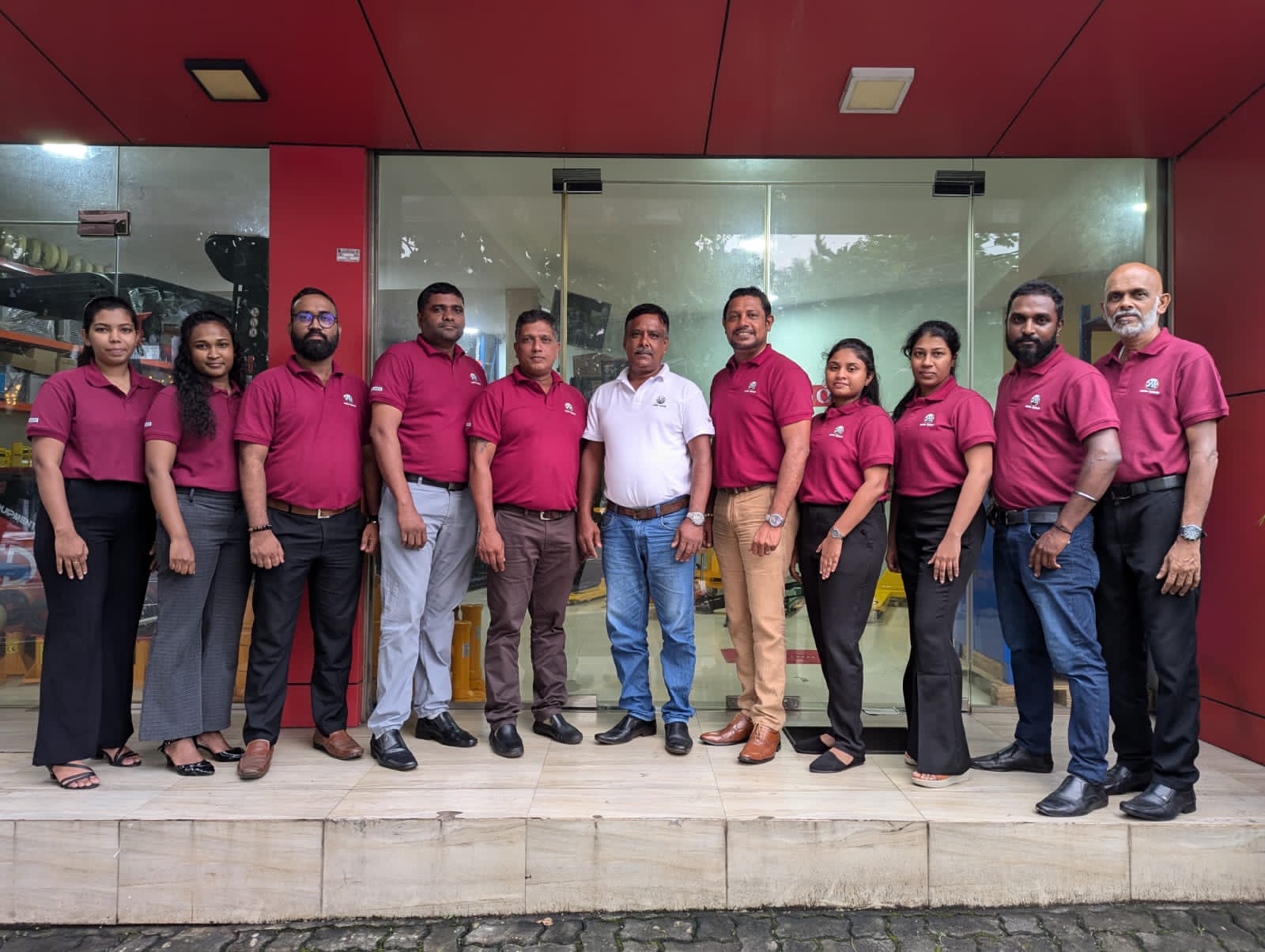 Corporate team in maroon embroidered Mezzo polos outside their storefront