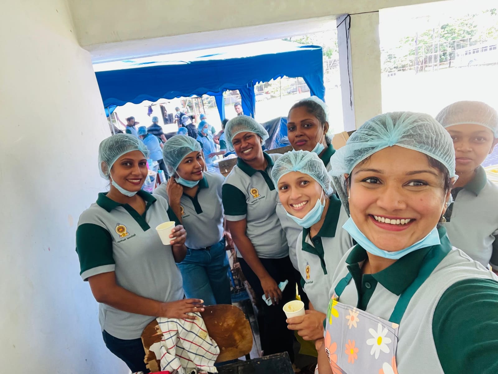Ministry of Buttala Region kitchen volunteers in pale grey and green Mezzo polos