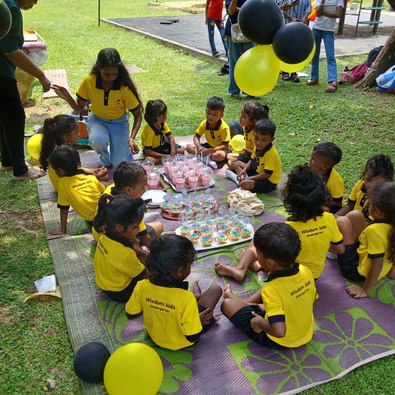 Wisdom Kids Kindergarten children in yellow and black polos at a birthday picnic